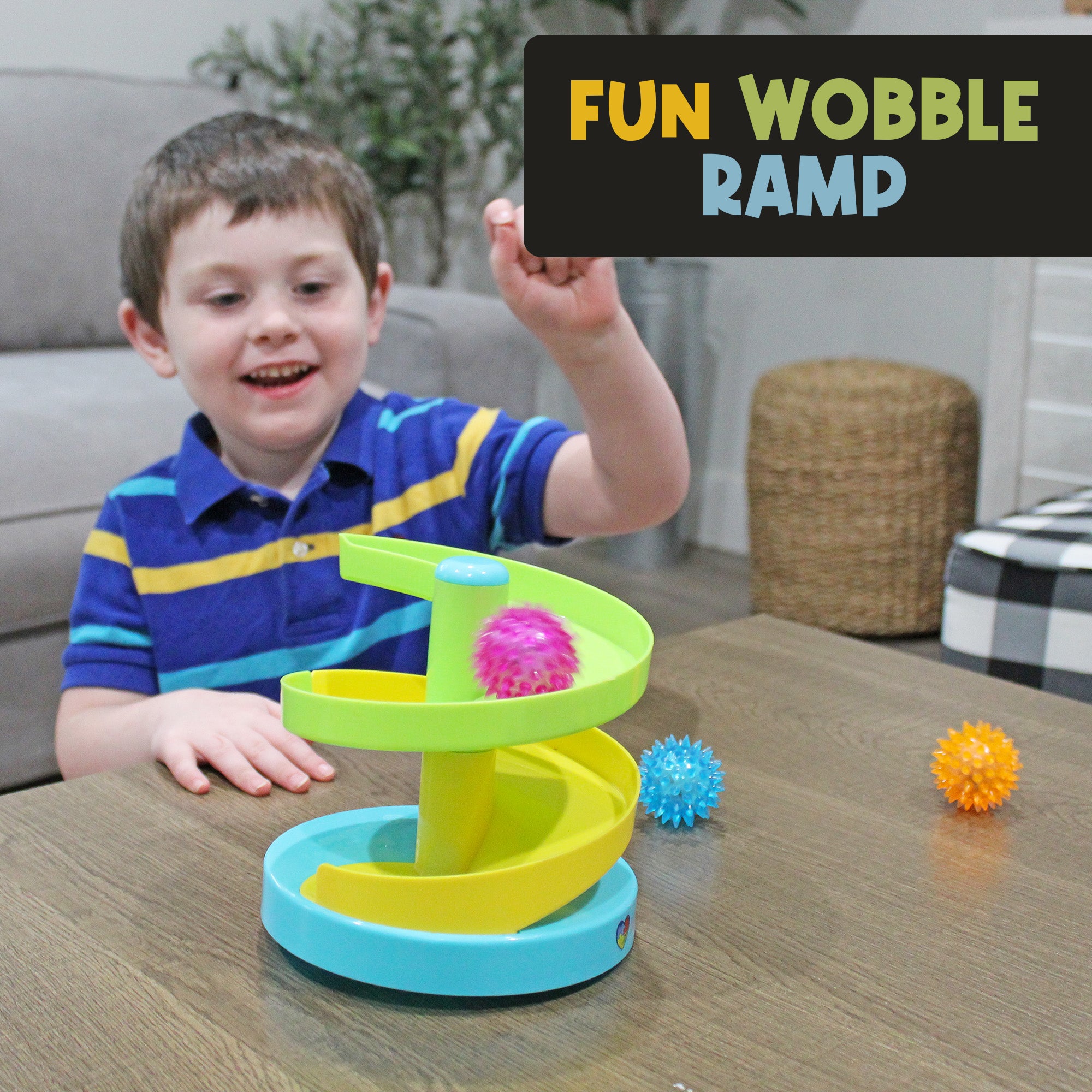 Child watching a textured ball roll down the tabletop wobble-ramp configuration of the MEAVIA Roll & Drop Sensory Toy
